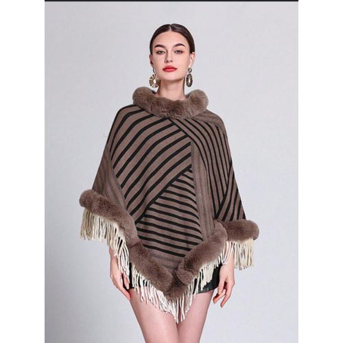 Generic une femme portant un poncho elegant avec un motif raye marron et noir. Le poncho est borde de fourrure autour du col et de l ourlet. Il est egalement orne de franges